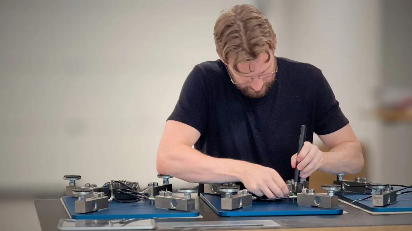 Claes assembling force plates at the workbench in the CC Athletics workshop