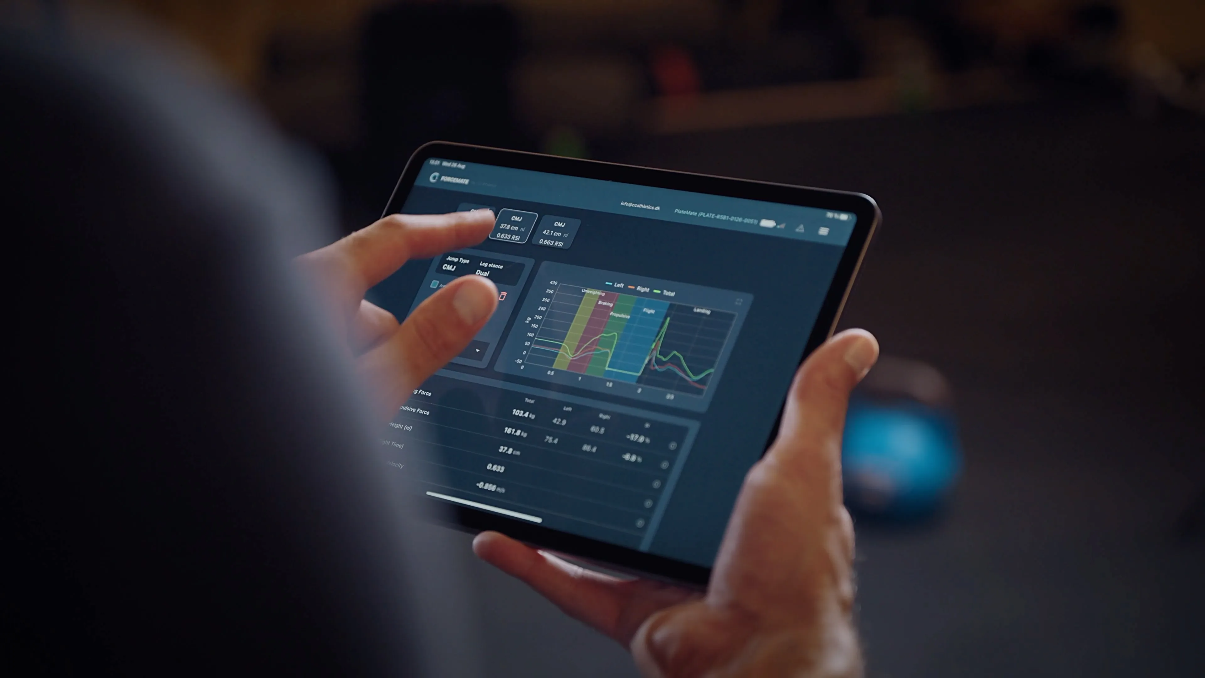 Coach reviewing countermovement jump results in the ForceMate app on a tablet — force-time curve with left and right metrics